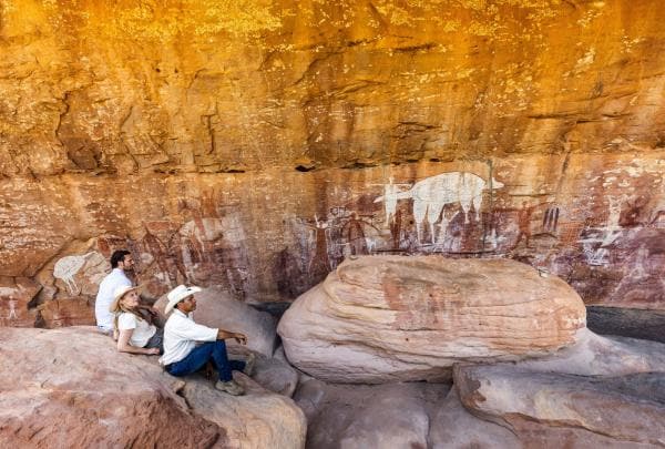 An Aboriginal guide sharing rock art with visitors on a Jarramali Rock Art Tour in Queensland