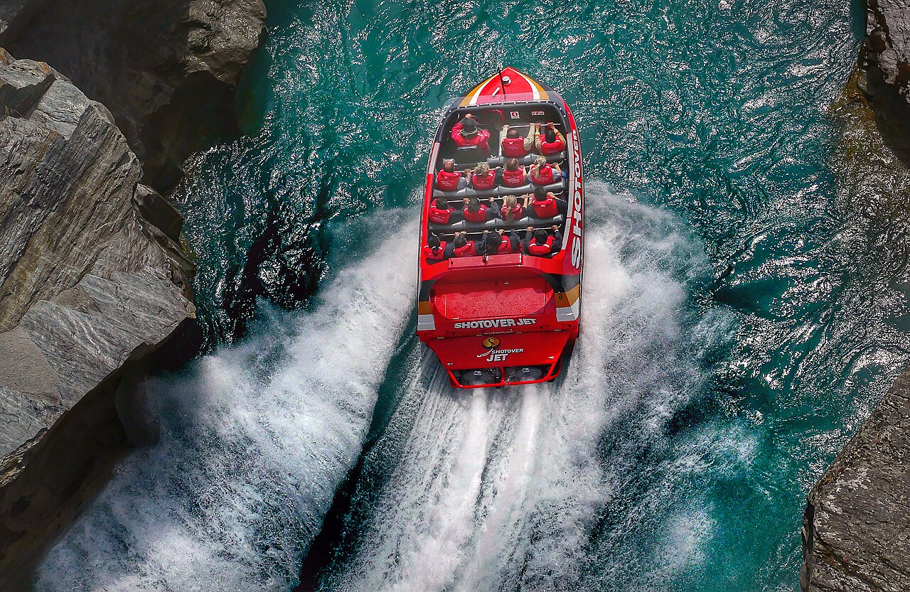 A jet boat carrying guests through a rocky river canyon